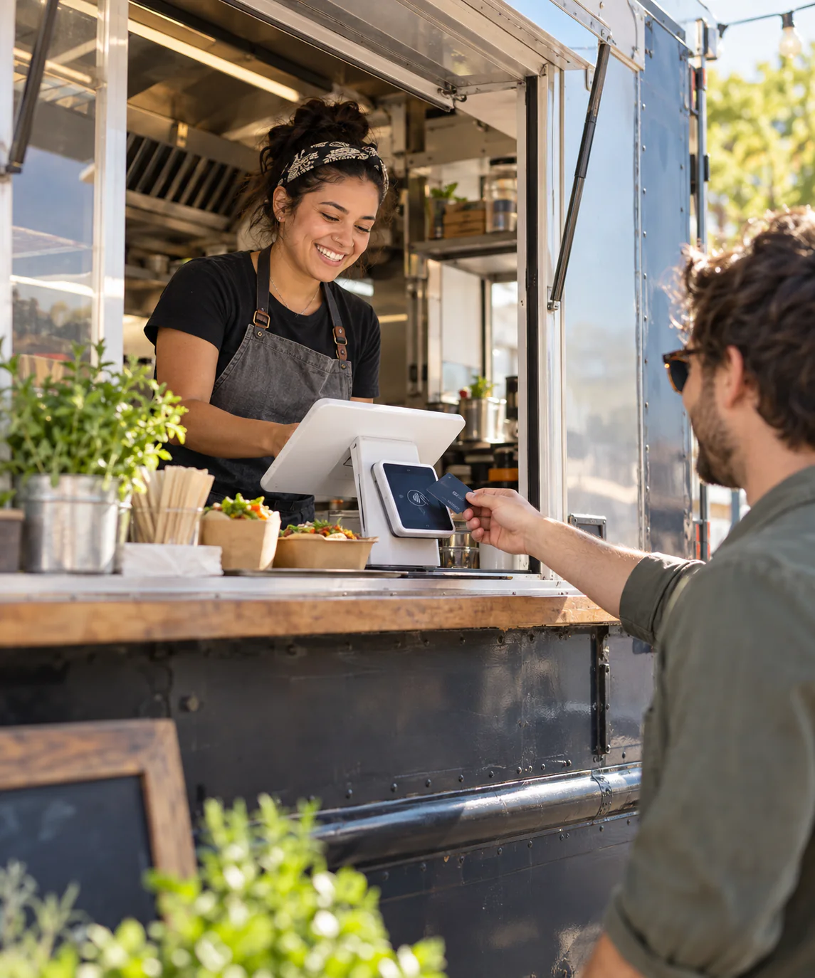 Independent food truck operator accepting a card payment at the service window